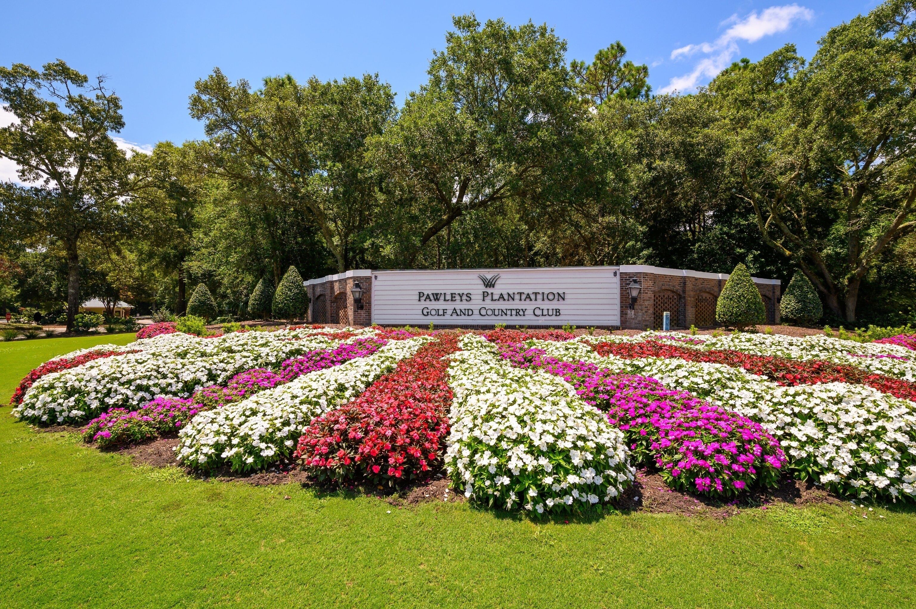 Pawleys Plantation Golf and Country Club with a well-maintained garden featuring rows of flowers and a brick building.