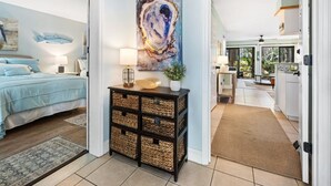 A bedroom with a bed, bedside table, lamp, and a painting. - 55-2 Low Country Get-a-way 2 Bedroom Condo (Pawleys Island)