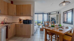 Una cocina moderna con armarios de madera, microondas y un comedor con mesa y sillas de madera.