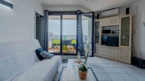 Una sala de estar moderna con un sofá, una mesa de centro y un mueble para televisión.