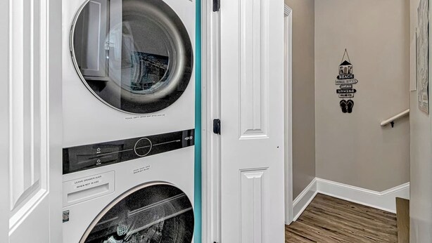 A laundry room with two stacked washers and dryers, a white door, and a wall with a 'BEACH HOUSE RULES' sign. - Ocean Views! 5BR Beach House Steps to Beach! (Myrtle Beach)