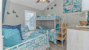 A room with bunk beds, a ceiling fan, and wall art. - Ocean Views! 5BR Beach House Steps to Beach! (Myrtle Beach)