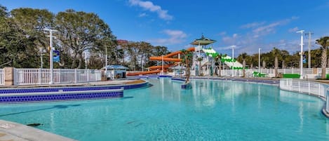 A swimming pool with a water slide and a covered area.