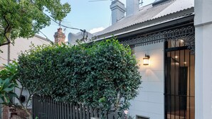 A house with a black picket fence, a brick wall, and a window with a black metal gate. - Alf and Lisa's Luxury Glebe House - 2BR, 2BA With Free Lockup Parking (Glebe)