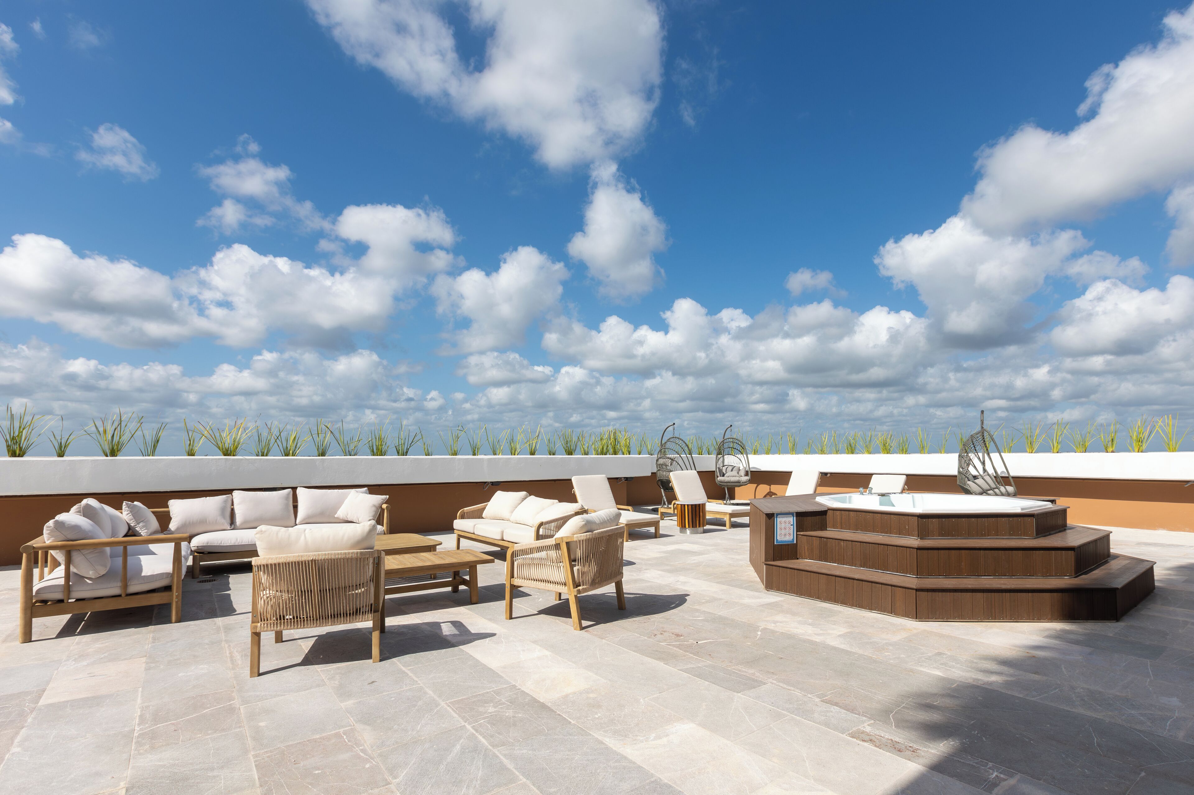 Eine Dachterrasse mit Sitzgelegenheiten im Freien, einem Whirlpool und Blick zum Himmel.