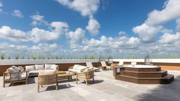 Eine Dachterrasse mit Sitzgelegenheiten im Freien, einem Whirlpool und Blick zum Himmel.