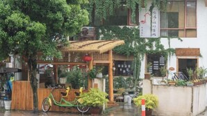A traditional Japanese building with a wooden structure and potted plants. - Leisurely residence (Jinyun)