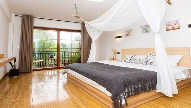 A bedroom with a bed, a balcony, a ceiling fan, and a view of greenery outside. - Leisurely residence (Jinyun)