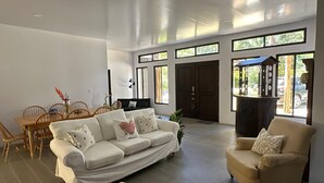 Una sala de estar amplia con un sofá, sillones y una mesa de comedor.