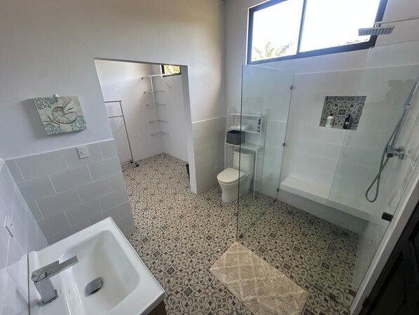 Un baño con bañera, inodoro y zona de ducha.