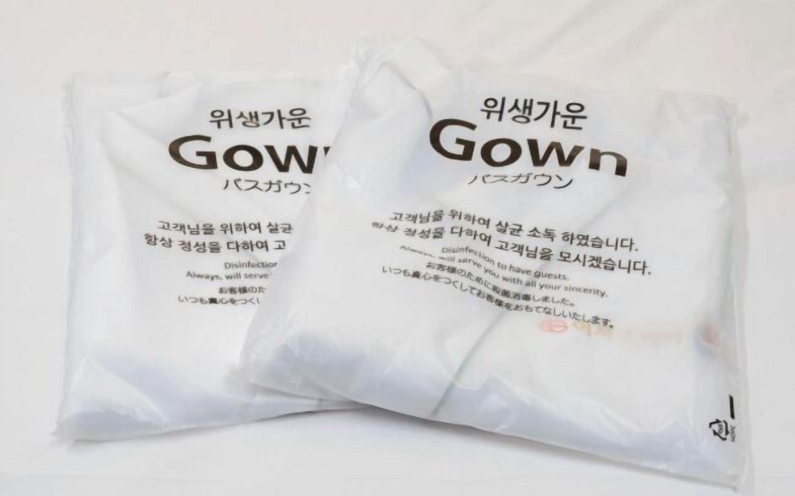 Twee witte plastic zakken met tekst in het Koreaans en Engels, waaronder het woord 'Gown'.
