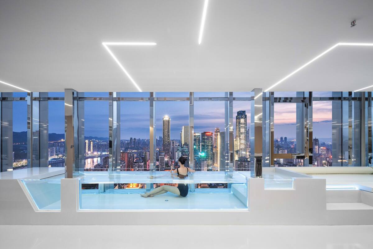 A modern interior with a city view, large windows, and a minimalist design.