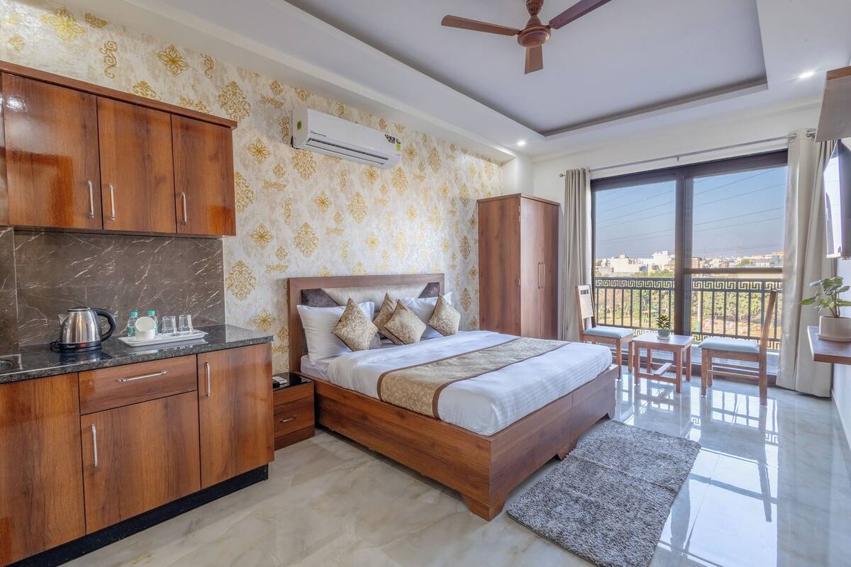 Een slaapkamer met een bed, houten kasten, een nachtkastje en een balkon met uitzicht.