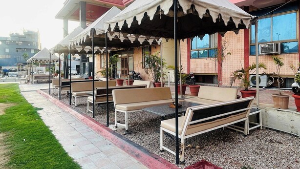Un patio con mobiliario exterior y un edificio al fondo.