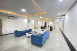 Eine moderne Lobby mit blauen Sofas, einem Couchtisch und einer Rezeption.