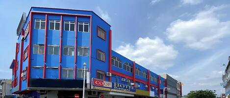 Un hotel con fachada azul, varias ventanas y un cartel que dice 'Coop Hotel'.