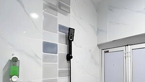 A shower with a handheld showerhead and a wall-mounted control panel. - Coop Hotel Kangar (Kangar)