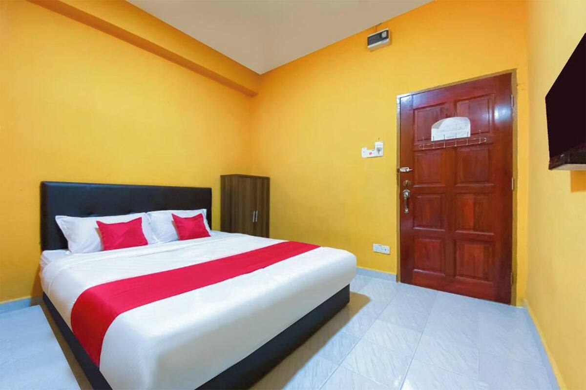 Une chambre d’hôtel avec un lit, une armoire et une porte.