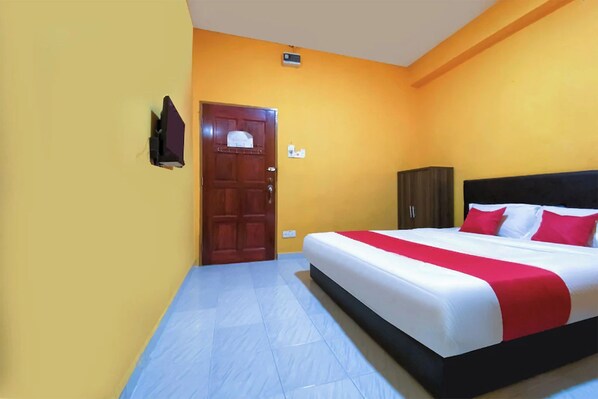 Una habitación con una cama, una puerta de madera y un armario.