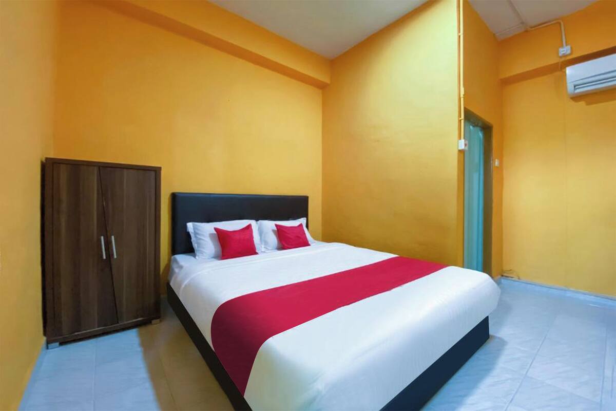 Une chambre d’hôtel équipée d’un lit, d’une armoire et d’un appareil de climatisation.