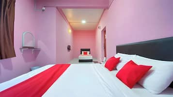 Una habitación de hotel con cama, mesita de noche, espejo y una pequeña mesa.