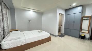 A modern bedroom with a bed, wardrobe, and a bathroom visible through an open door.