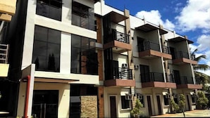 A multi-story building with balconies and large windows. - Hotel Ramon Bukidnon (Valencia)