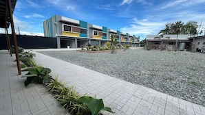 A modern building with a tiled courtyard and potted plants.