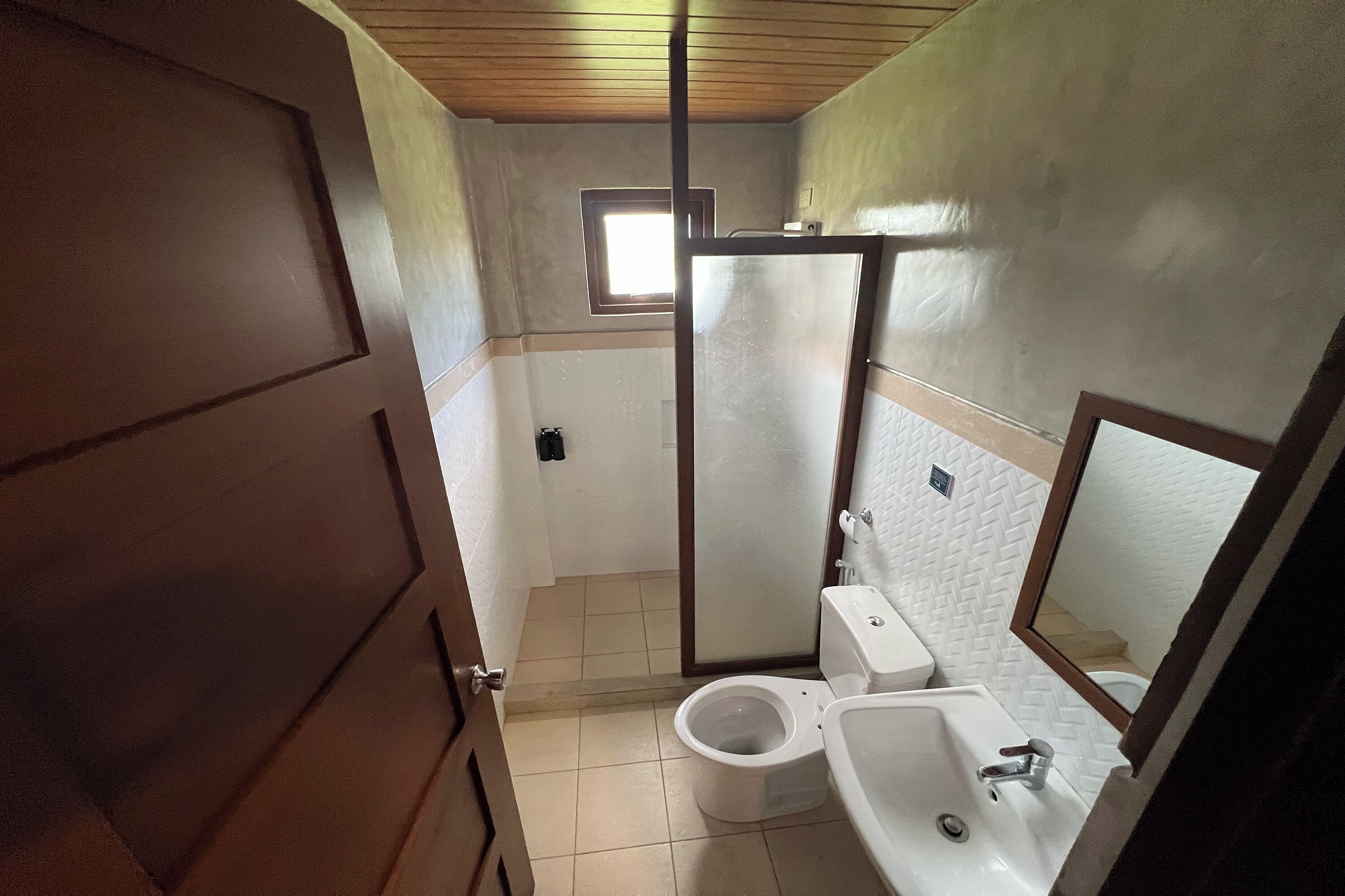 A bathroom with a toilet, sink, and shower.