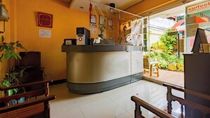 Un espace d’accueil doté d’un comptoir incurvé, d’un banc en bois et d’une porte vitrée donnant sur l’extérieur.