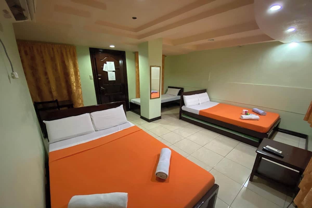 A hotel room with two beds, a desk, and a mirror.