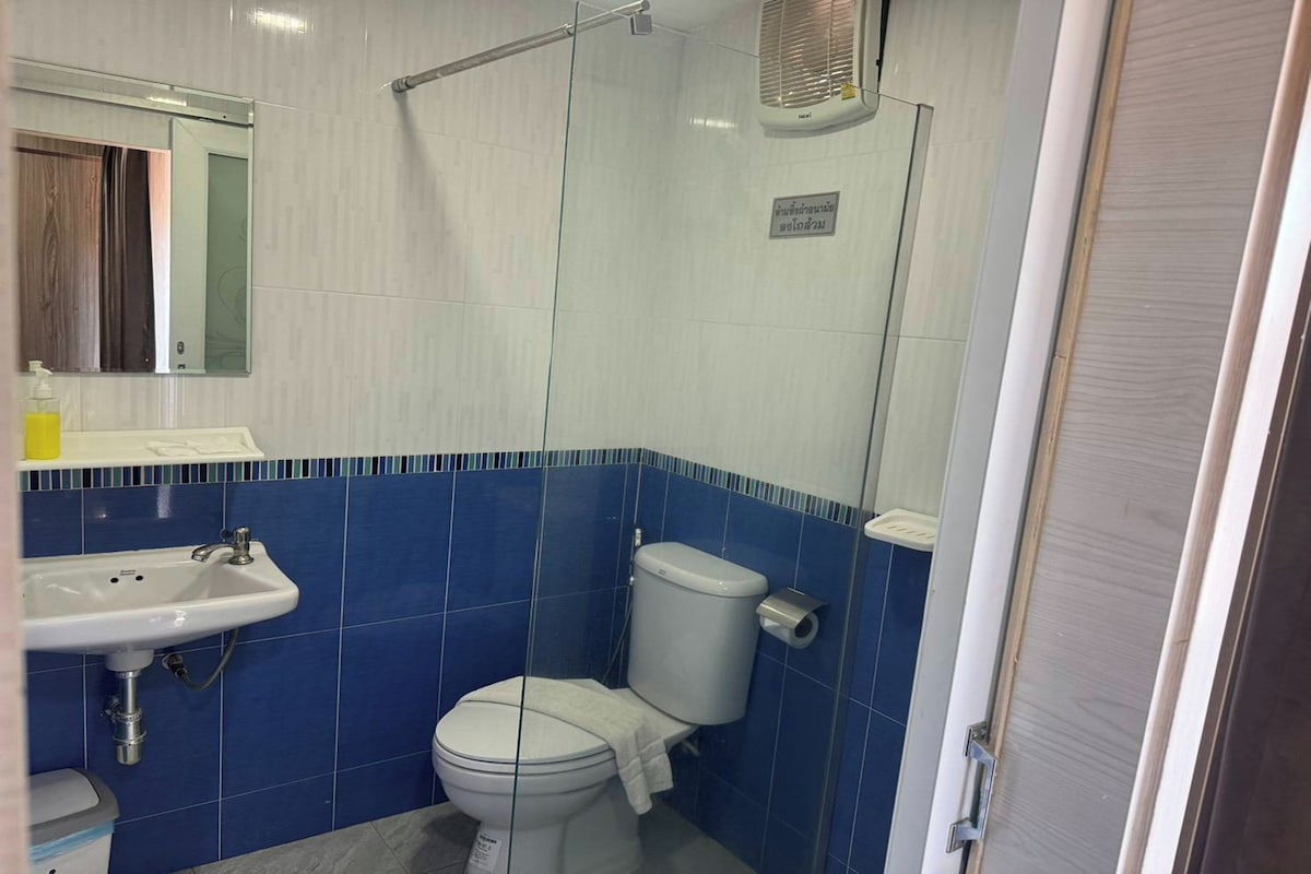 A bathroom with a white sink, a toilet, and a shower area.