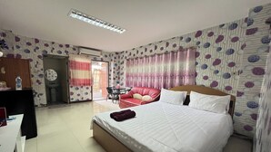 A hotel room with a bed, a desk, a chair, and a small table. - Green Place 107 (Bangkok)