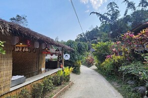 Un bâtiment rustique avec un toit de chaume, une véranda en bois et une enseigne indiquant qu’il s’agit d’un restaurant.