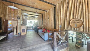 A wooden interior with a sofa, chairs, and a dining area. - Mae Mae Home (Chiang Dao)
