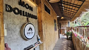 A wooden building with a sign that reads "Mon Doiluvang." - Mae Mae Home (Chiang Dao)