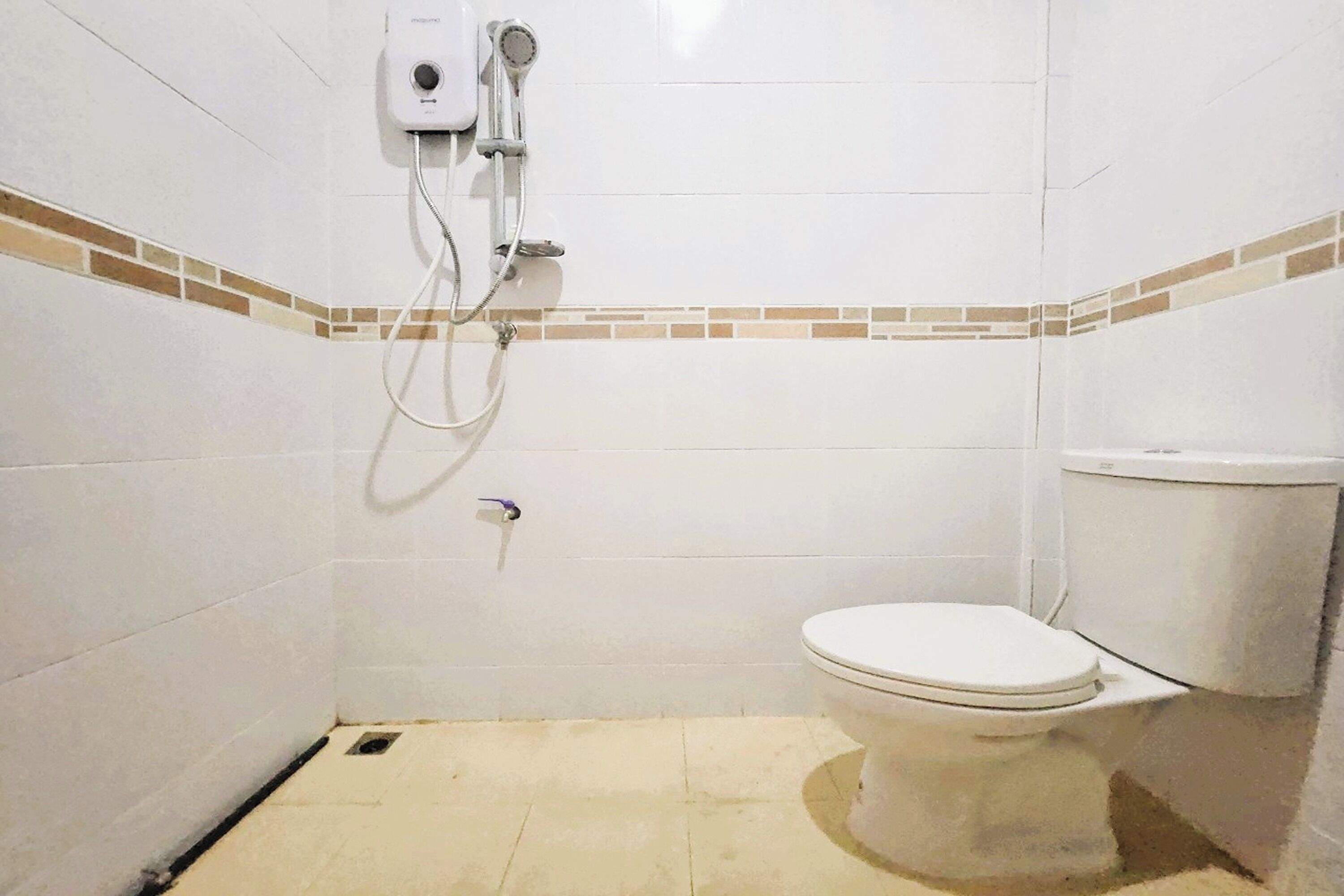 Un baño pequeño con azulejos, un inodoro y una ducha.