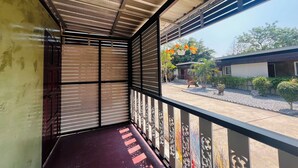 Un balcón con vista a un jardín y un edificio.