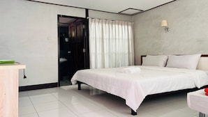 Una habitación de hotel con cama, escritorio, baño y zona de ducha.