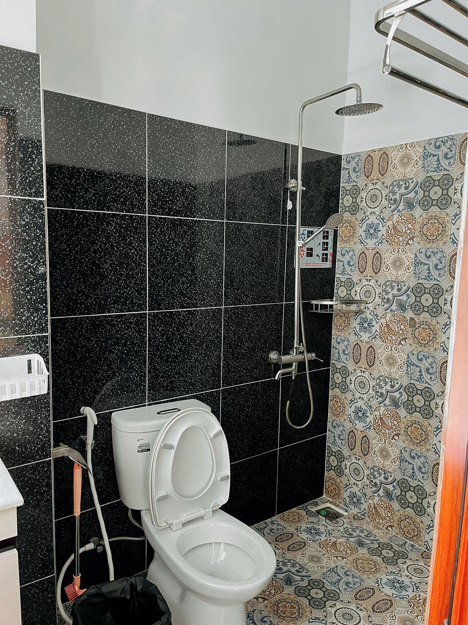 A bathroom with a toilet, a shower, and a hand dryer.