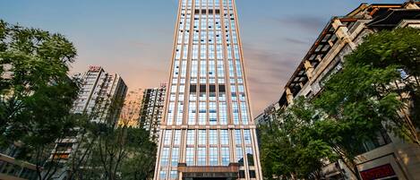 A tall, modern building with a symmetrical facade, large windows, and a central entrance.