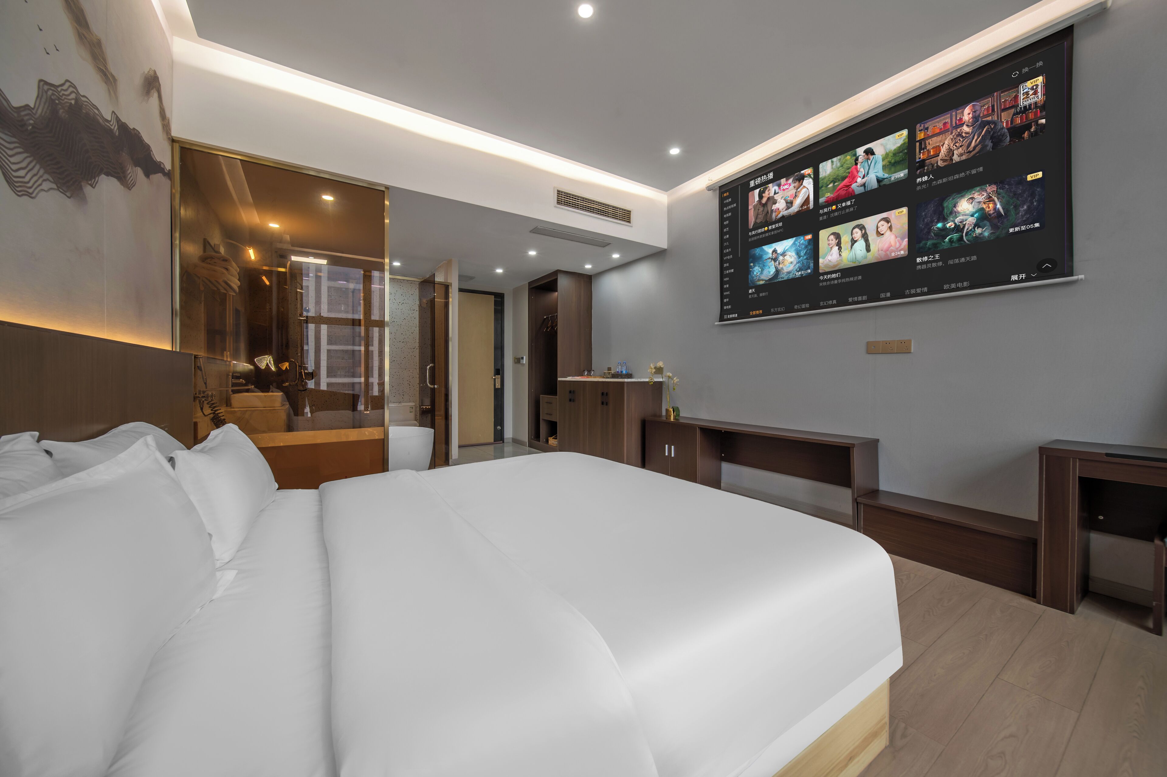 Een moderne hotelkamer met een groot bed, een flatscreen televisie aan de muur en een nachtkastje van hout.