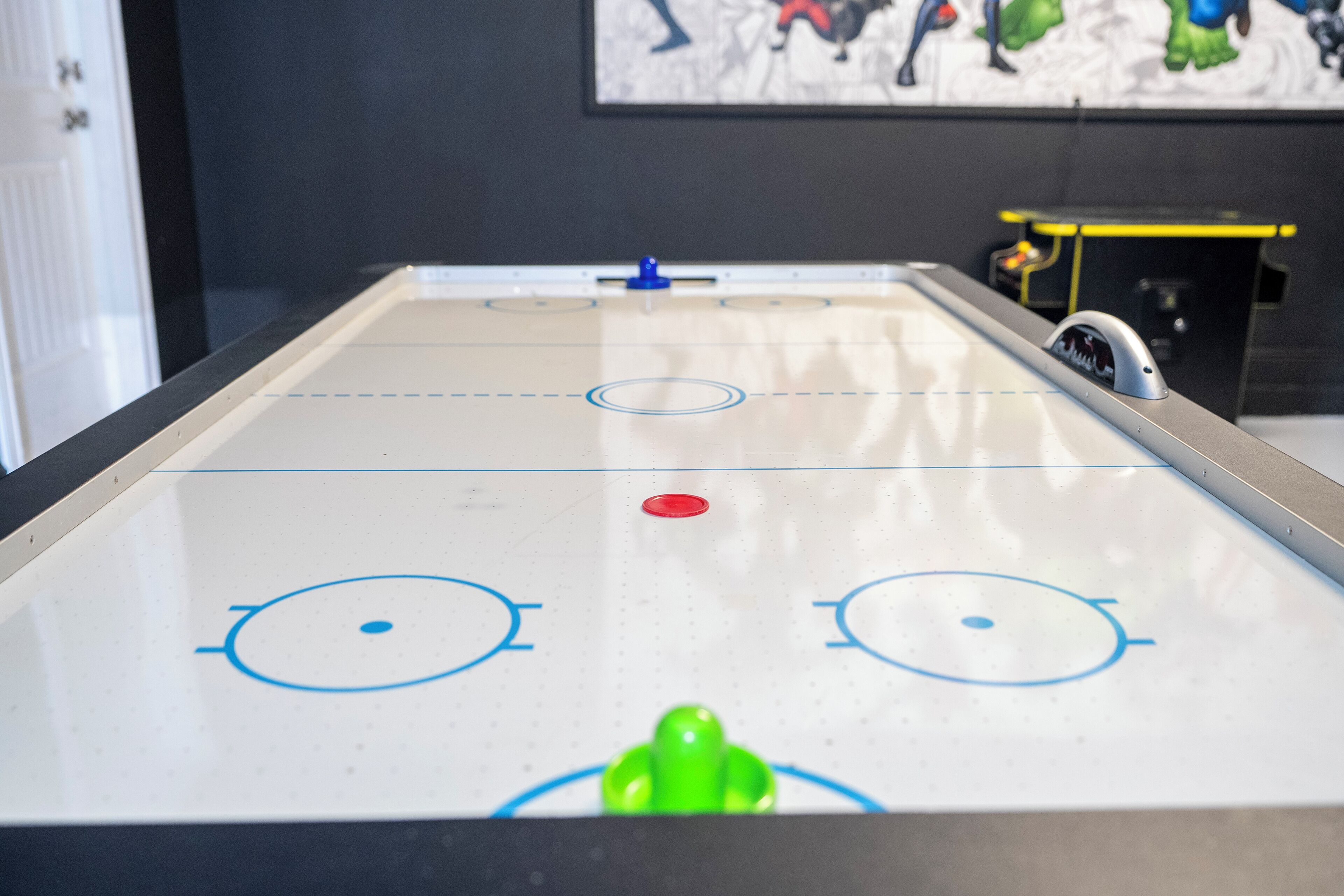 A table hockey game with a green puck and a blue goal.