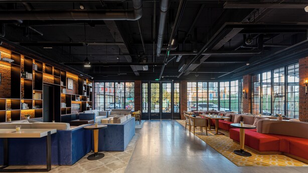 A modern interior with a bar area, seating, and large windows. - Unite Hotel Changzhou Qingguo Lane (Changzhou)