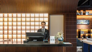 A reception desk with a modern design, featuring a wooden panel backdrop and a digital screen. - Unite Hotel Changzhou Qingguo Lane (Changzhou)