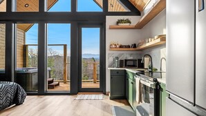 Una cucina moderna con una grande finestra, un pavimento in legno e vista sulle montagne.