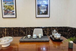 A hotel room with a marble countertop, a dining table, and framed pictures on the wall. - Fuzhou Rongtong Meifeng Hotel (Fuzhou)