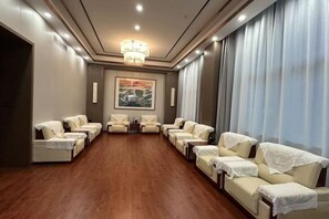 A room with multiple seating areas, a chandelier, and a large window with curtains. - Fuzhou Rongtong Meifeng Hotel (Fuzhou)