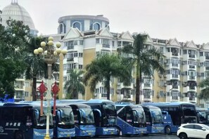 A row of buses parked in front of a building with a dome and balconies. - Fuzhou Rongtong Meifeng Hotel (Fuzhou)