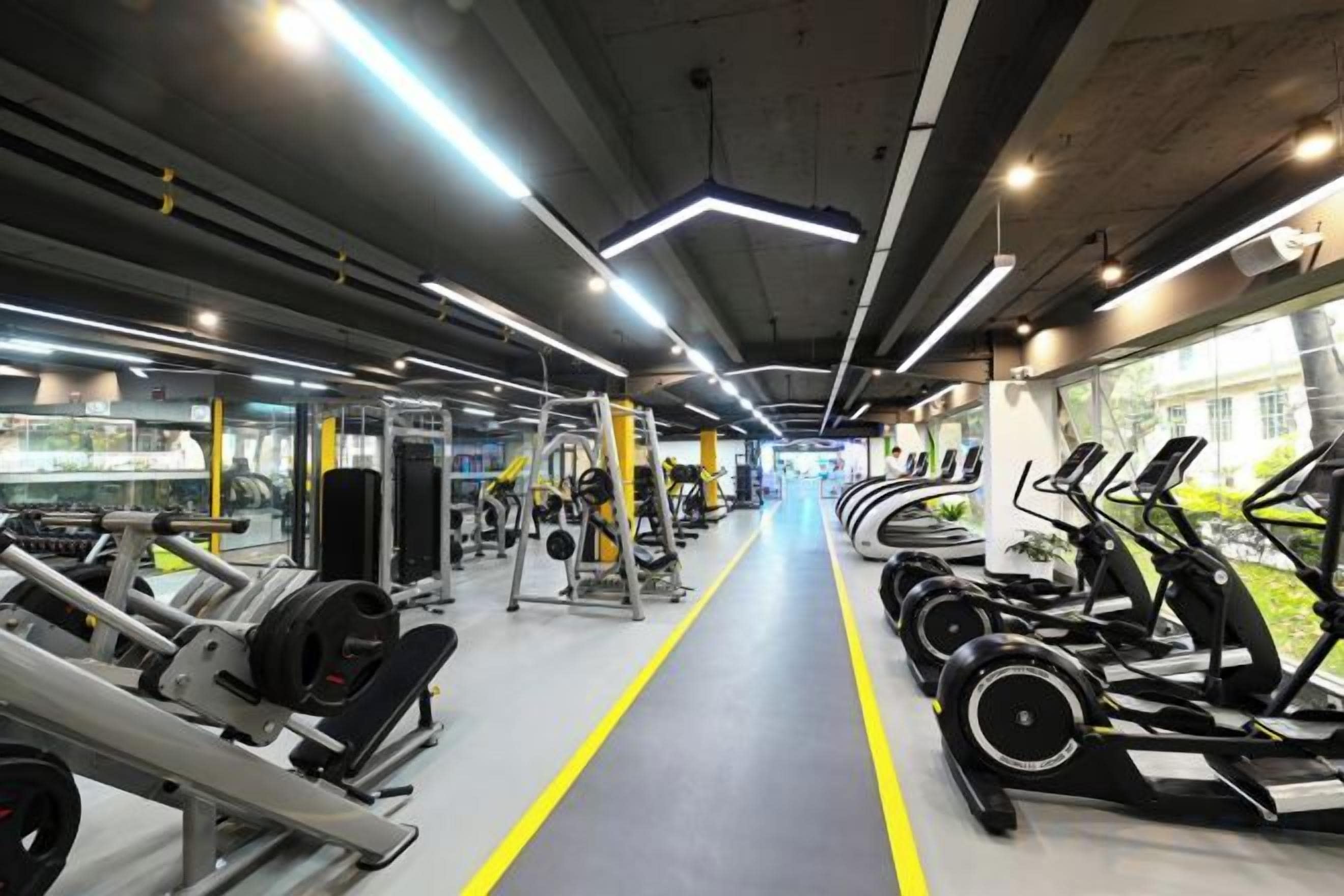 A gym with treadmills, weight machines, and a central walking path.